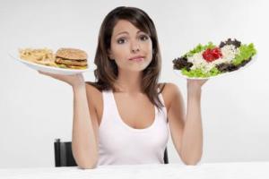 Woman choosing between a hamburger and salad
